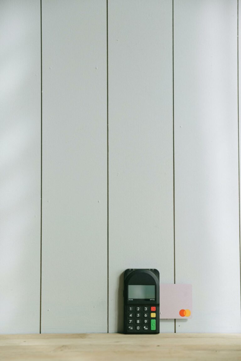 A sleek payment terminal with buttons against a white wooden background, ideal for finance concept.